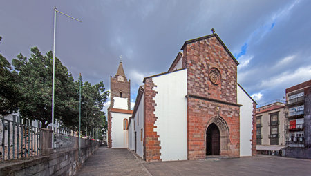 Historic Cathedral of Funchal built of volcanic stone under dramatic sky on the island of Madeiraの写真素材
