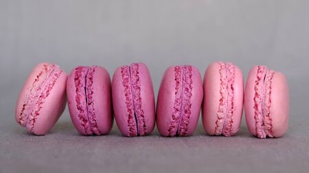 Pink and purple fruity flavour french macarons on grey background. Copy space. Pastry and confectioneryの写真素材