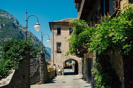 Small narrow street in Bard, Italy. Medieval stone town in the Aosta Valley mountainous region in northern Italy. A tower house crosses a road.の写真素材