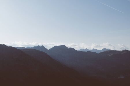Beautiful alpine landscape with mountain range silhouette during sunset.の写真素材