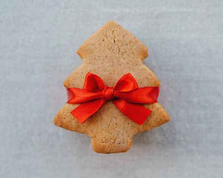 Stack of shortbread cookies in the shape of Christmas tree with beautiful red ribbon. Sweet gift.の写真素材