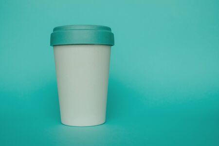 Reusable plastic free eco friendly bamboo cup for take away coffee on light blue background. Copy space. Bring your own cup concept. Zero waste, sustainable lifestyle.の写真素材