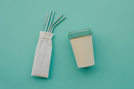 Reusable eco friendly bamboo cup and stainless steel metal straws on mint background.の写真素材