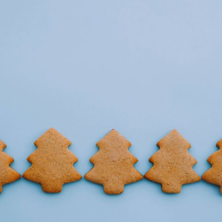 Holiday cookies in the shape of Christmas tree on light blue background. Space for text.の写真素材