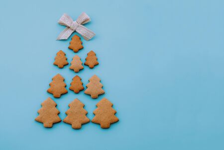 Christmas tree made of homemade shortbread cookies on light blue background.の写真素材