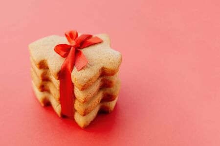 Stack of shortbread cookies in the shape of Christmas tree tied with beautiful red ribbon.の写真素材
