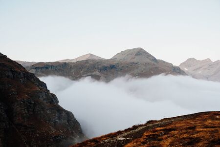 Beautiful view with mountain peaks in the clouds. Alpine landscape in pastel tones. Aerial view. Space for text.の写真素材