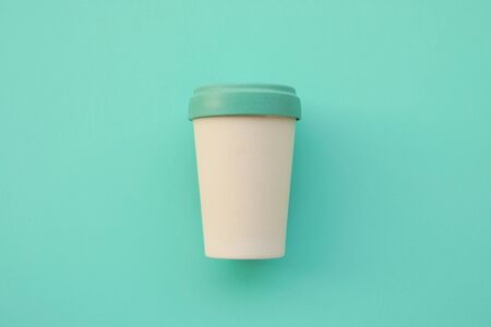 Reusable eco friendly bamboo cup for take away coffee on mint background.の写真素材
