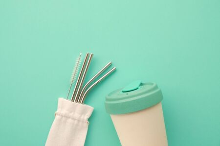 Reusable eco friendly bamboo cup and stainless steel metal straws on mint background.の写真素材