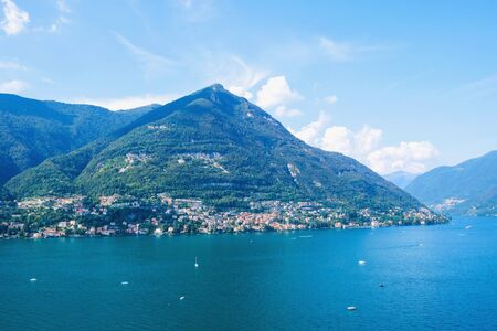 Beautiful view of Como Lake or Lago di Como in summer. Popular tourist attraction in Lombardy, Northern Italy. Summer vacations concept.