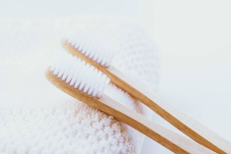 Stylish natural eco friendly toothbrushes with wooden bamboo handle on white towel background. Oral hygiene concept. Copy space. Reduce plastic waste, sustainable lifestyle concept.の写真素材
