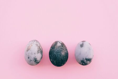 Natural dyed grey and white colored eggs on pastel pink background.の写真素材