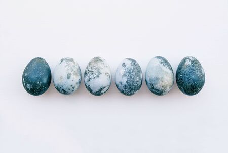 Natural dyed blue and azure colored eggs on white background, top view. Flat lay. Happy Easter. Space for text.の写真素材