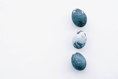 Natural dyed blue colored eggs on white background, top view. Flat lay. Happy Easter. Copy space.の写真素材