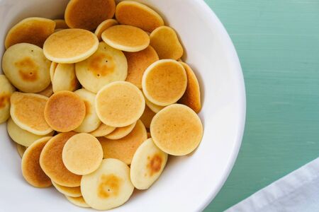 Delicious freshly cooked pancake cereal in a bowl, top view, close up. Mini pancakes. Food for kids. Breakfast ideas.の写真素材