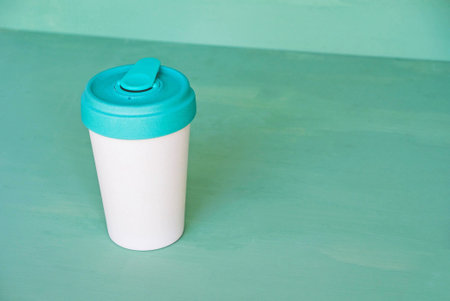 Stylish reusable eco-friendly bamboo cup on mint green background. Copy space. Zero waste, plastic free, sustainable lifestyle, bring your own cup concept.の写真素材