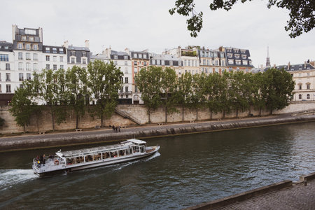 View of Paris city with beautiful buildings near the Seine river at sunset.