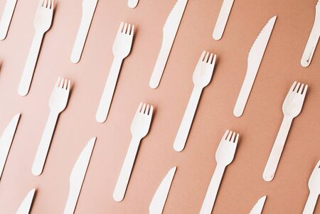 Pattern made of biodegradable eco friendly wooden cutlery on brown background. Zero waste, plastic free and sustainable lifestyle concept. Top view, flat-lay.の写真素材