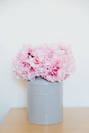 Beautiful bouquet of fresh pink peony flowers in full bloom in vase against white wall background. Copy space. Modern minimal home interior. Mother's day, Birthday card.の写真素材