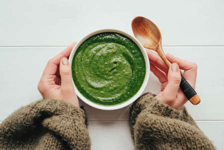 A bowl of hot healthy green vegetable cream soup, from above.の写真素材