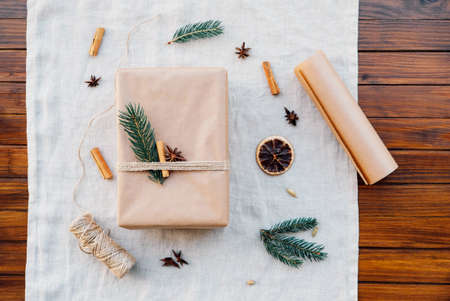 Wrapping gifts with natual decorations such as fir branch, cinnamon sticks, dry orange slices.の写真素材