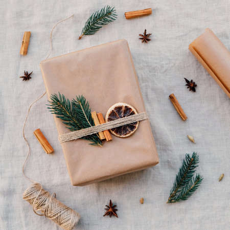 Wrapping gifts with natual decorations such as fir branch, cinnamon sticks, dry orange slice. Zero waste Christmas concept. Plastic free holidays. Sustainable lifestyle.の写真素材