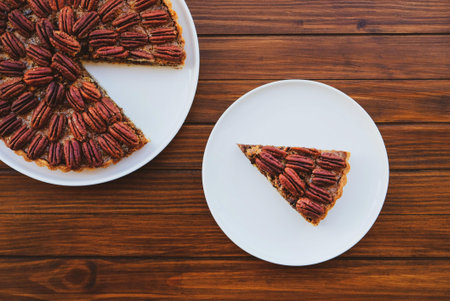 Piece of delicious freshly baked homemade pecan pie on wooden rustic background, close up. Popular...