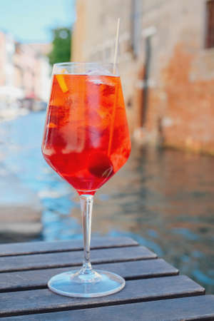 Glass of refreshing cocktail served on the deck bar in Venice. Traditional venetian aperitif drink. Venice background.の写真素材