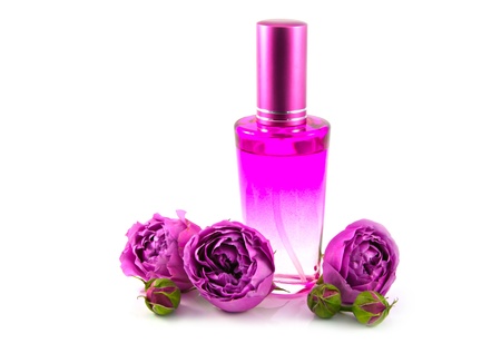 Bottle with cap of oriental natural perfume of rose water with three buds of pink rose on white background の写真素材