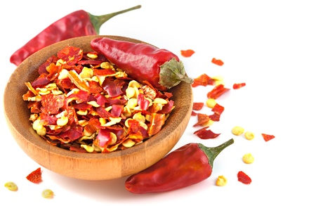 Wooden bowl with dried crushed chili red pepper isolatedの写真素材