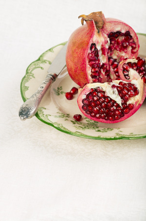 Opened red pomegranate on a rustic plateの写真素材