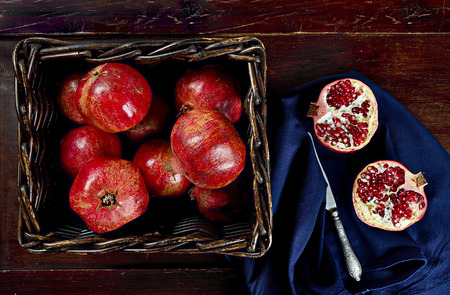 Red pomegranate and knife on a dark wooden backgroundの写真素材