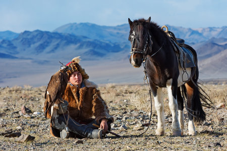 Bayan-Olgii, Mongolia - September 30, 2017: Unknown huntsman with Golden Eagle shows his experience...