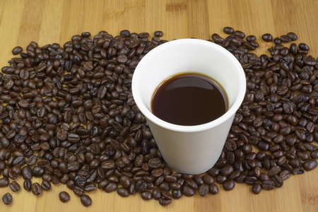 Cup of coffee and coffee beans on table.の写真素材