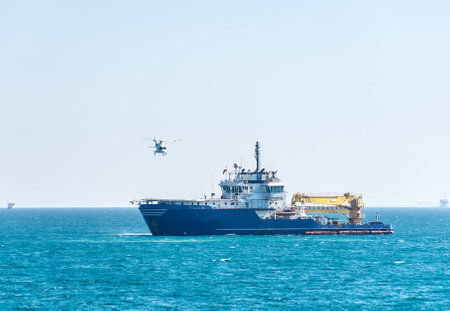 Helicopter take-off from the helideck of multirole offshore support vessel at some Saudi Arabian oilfieldの写真素材