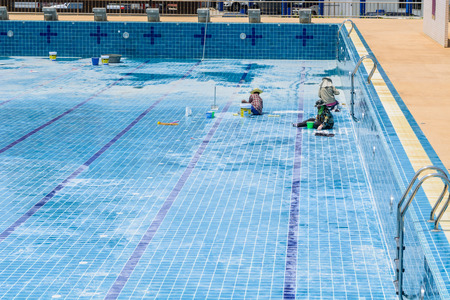 A group of technicians are repairing the damaged pool.の写真素材