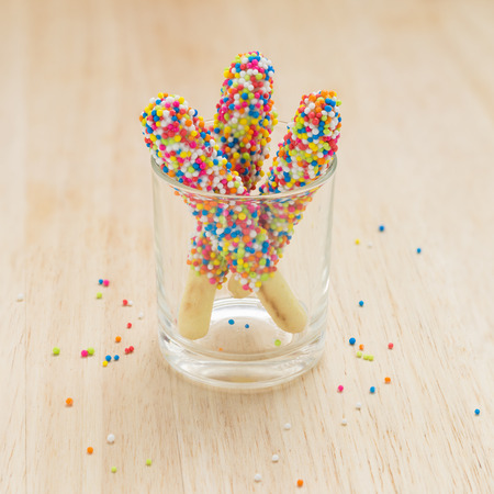Sweet bread sticks with chocolate and colorful sugar sprinkles.の写真素材
