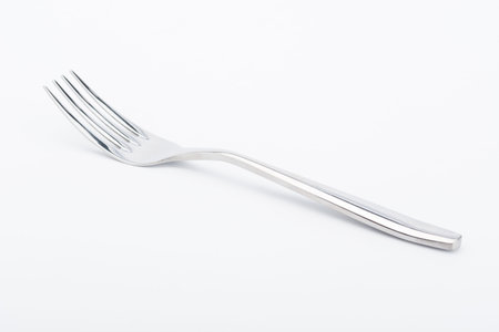 Shiny silver fork on white background