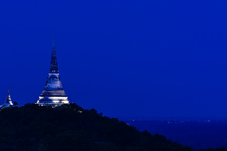 Thai-style white pagoda on top of hill in twilight time.の写真素材