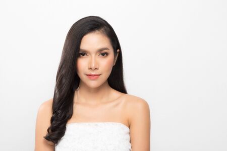 Beautiful asian woman with perfect skin and bare shoulders in profile isolated on gray background.の写真素材