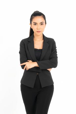 Young mixed race businesswoman wearing a black work suit with arms folded smiling isolated on white backgroundの写真素材