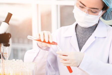 Scientist are experimenting tubes with medical glassware in a laboratory. Young scientist doing some research. in close up view.の写真素材