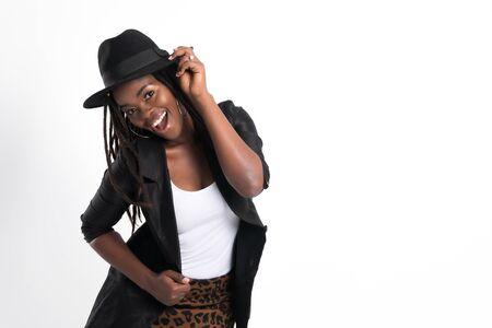 Confident in her style, Fashionable woman beautiful african woman with posing at studio shot in black leather jacket and wearing black hat isolated on white background.の写真素材