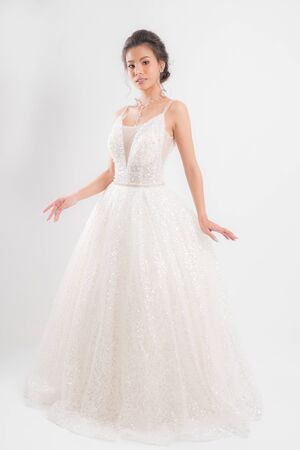 Beautiful bride portrait wearing a white wedding dress with a luxury at studio shoot isolated on white background.の写真素材