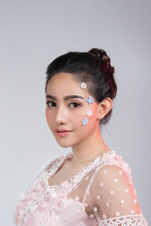 Fashion beauty makeup with flowers on face beautiful woman.の写真素材