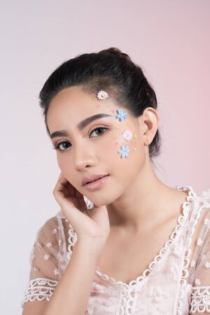 Fashion beauty makeup with flowers on face beautiful woman.の写真素材