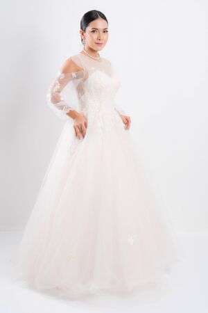 Beautiful bride portrait wearing a white wedding dress with a luxury at studio shoot isolated on white background.の写真素材