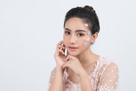 Fashion beauty makeup with flowers on face beautiful woman.の写真素材