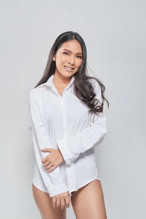 Beautiful asian woman with perfect skin and wearing a white shirt in profile isolated on white  background.の写真素材