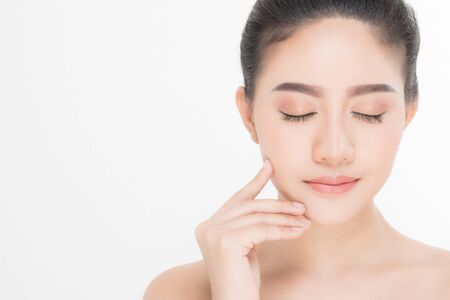 Beautiful Young Woman with clean fresh skin, Proposing a product. Gestures for advertisement on white backgroundの写真素材
